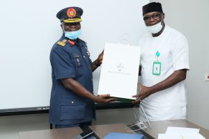 The Commandant Air Force Institute of Technology , Kaduna, Air Vice Marshal Abdulganiyu Olabisi receiving a gift item from the Executive Director Cooperates Services ,Rural Electrification Agency Chief Alaba Netufo